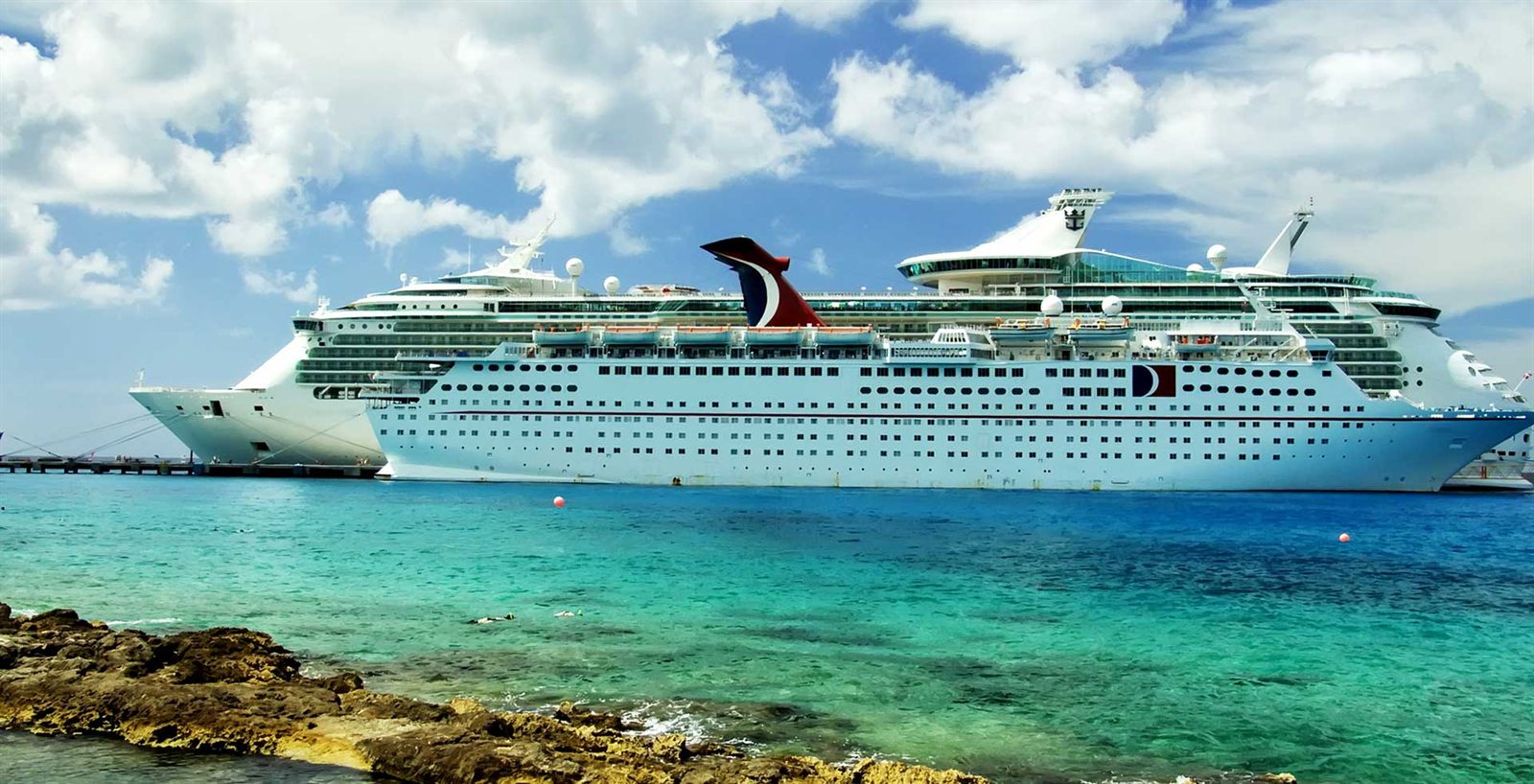 Carnival cruise ship off a turquoise Caribbean shore